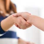 two women shaking hands