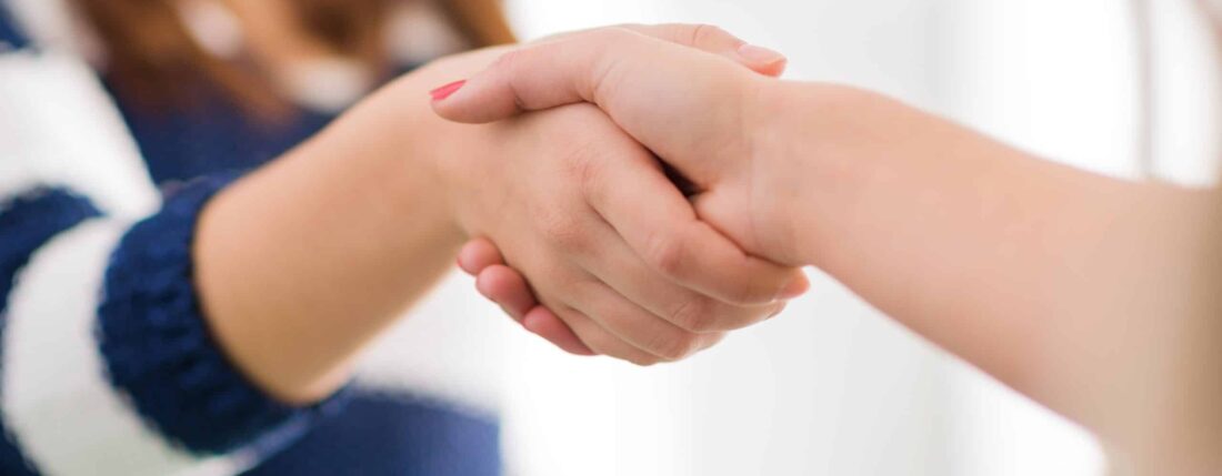 two women shaking hands